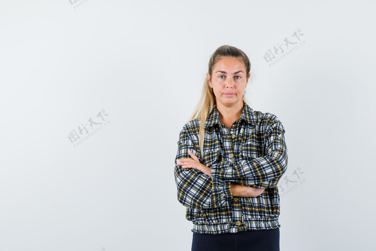 女士年轻的女士交叉双臂站在衬衫 短裤和看起来自信 前视图前面一个肖像