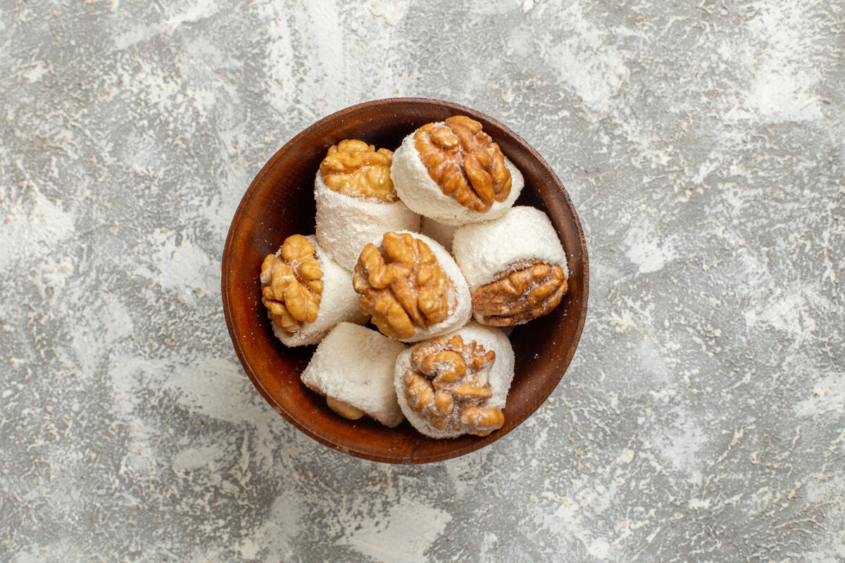 糕点俯视图胡桃木在白色背景上展示甜美的糖果饼干面包美味