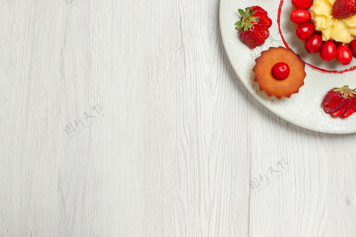 蛋糕俯瞰白色桌子上盘子里的水果蛋糕饼干西红柿肉