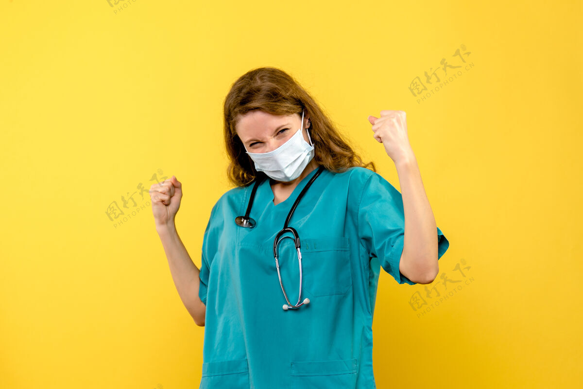 人黄色墙壁上戴着面具的女医生的正视图黄色保健欢喜