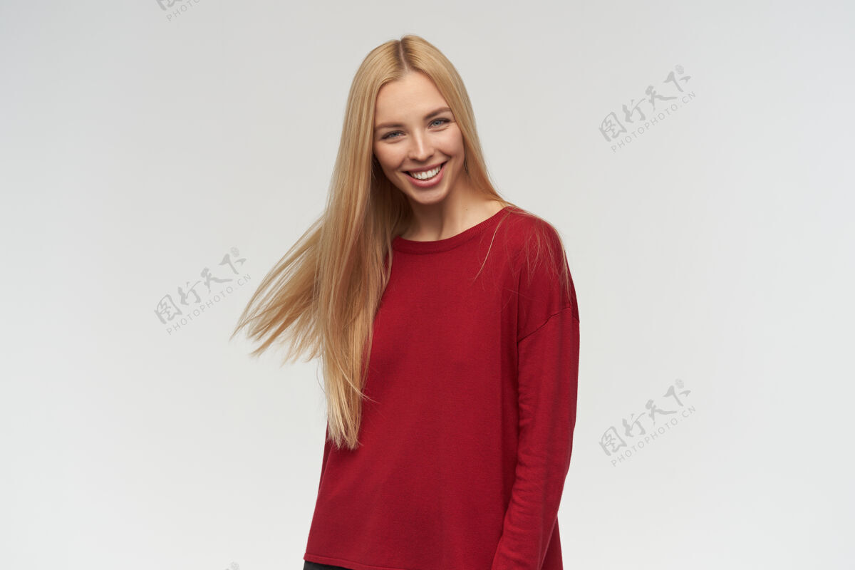 女性有吸引力的 金发长发的成年女孩的肖像穿着红色毛衣人和情感的概念看着镜头 在白色背景下孤立年轻成人毛衣