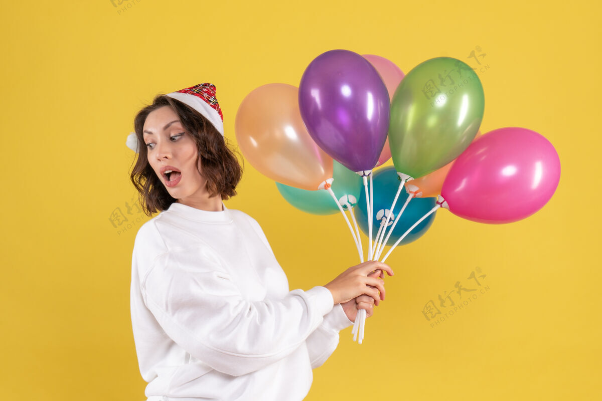 庆祝正面图美丽的女性手持五颜六色的气球站在黄色吹前面年份