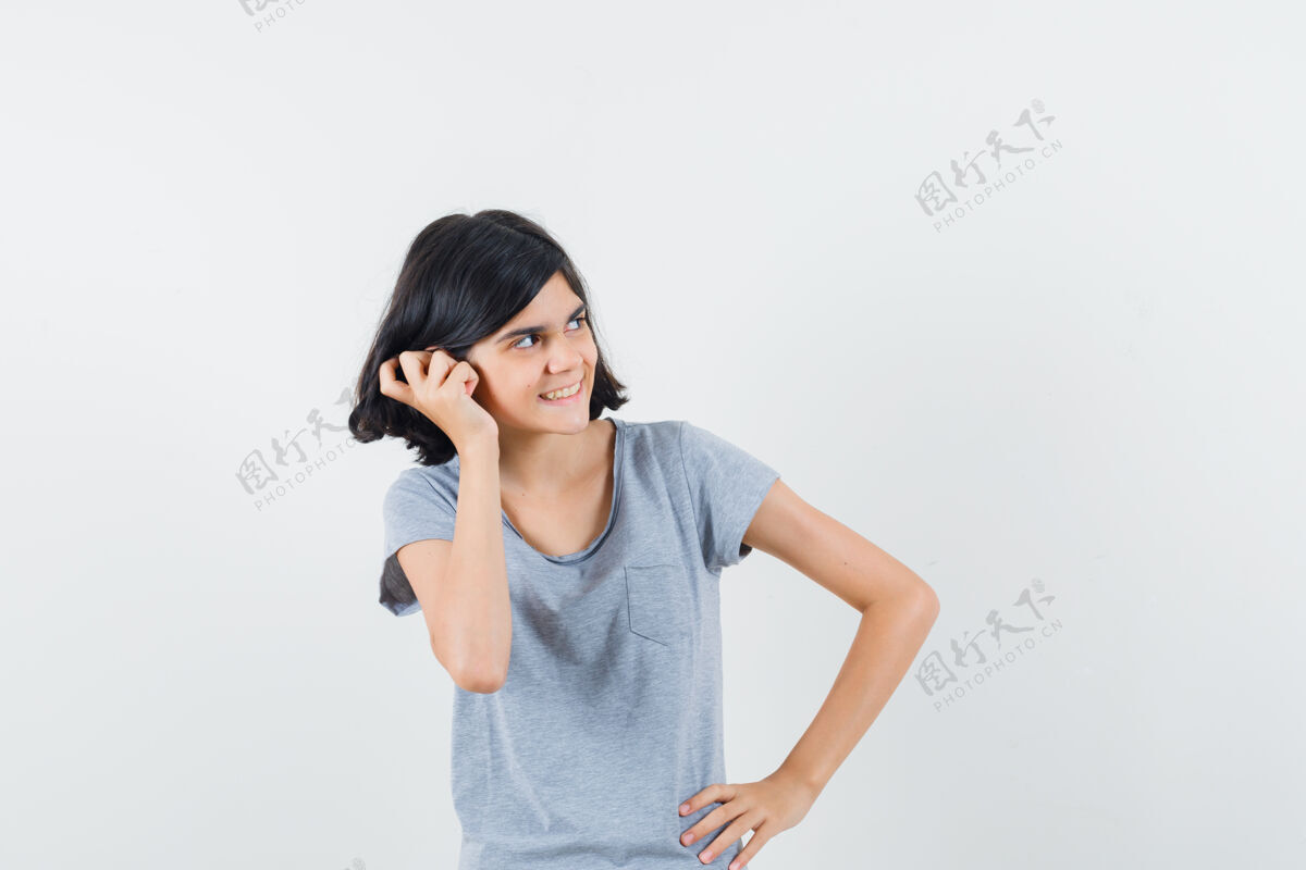 室内小女孩穿着t恤 手放在耳朵上 看起来很高兴 前视人小童年