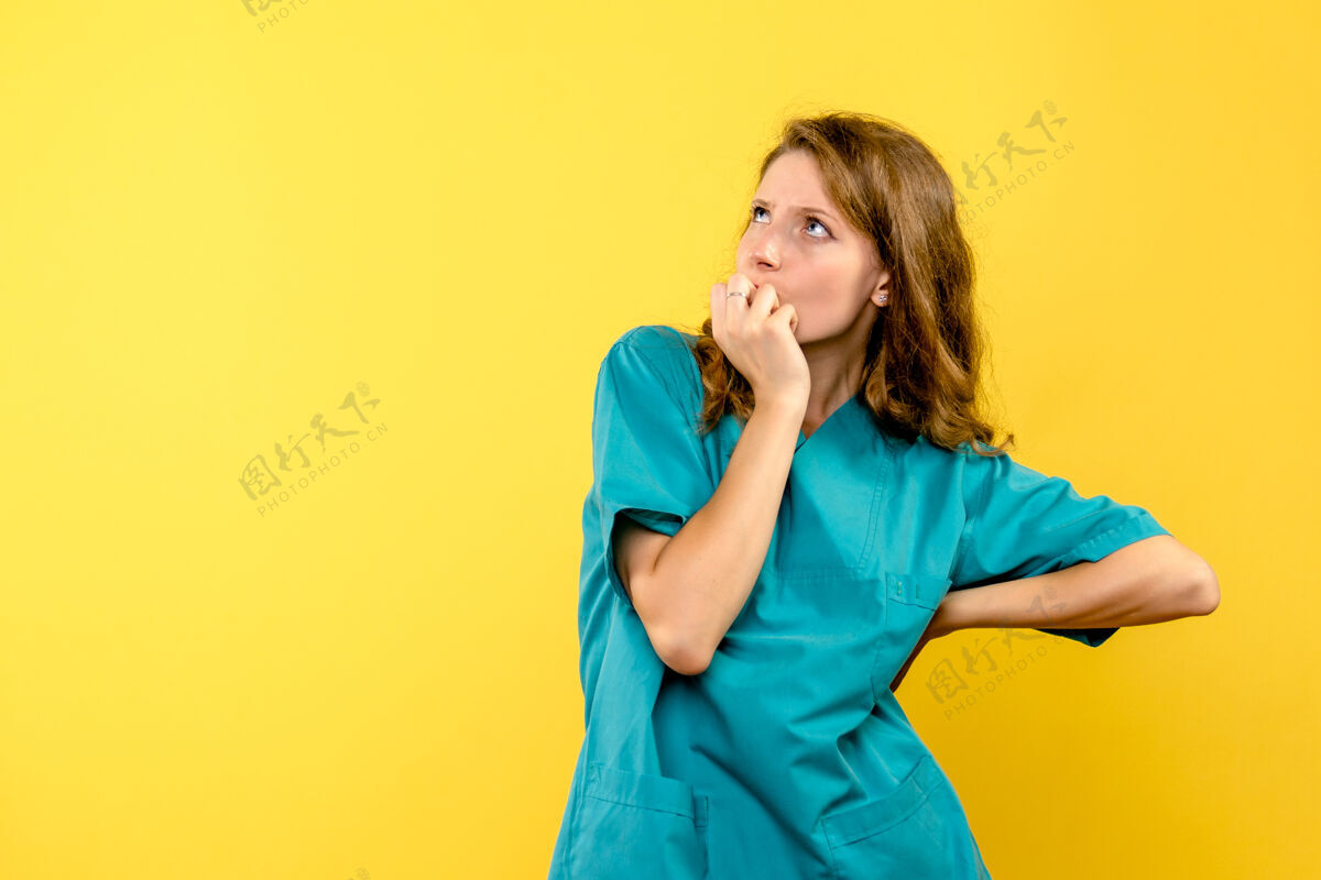 快乐女医生在黄墙上思考的正面图专业人漂亮