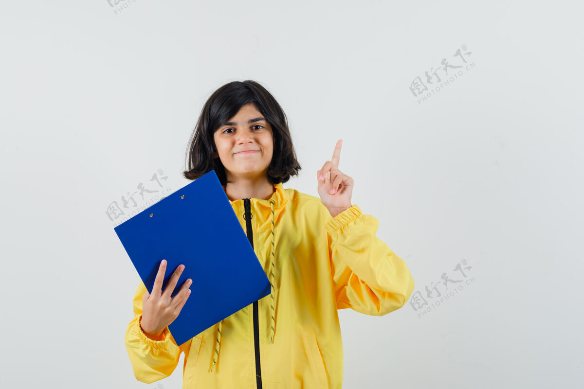 西班牙裔拿着剪贴板的小女孩 戴着黄色连帽衫 面带微笑正视图小脸欢乐