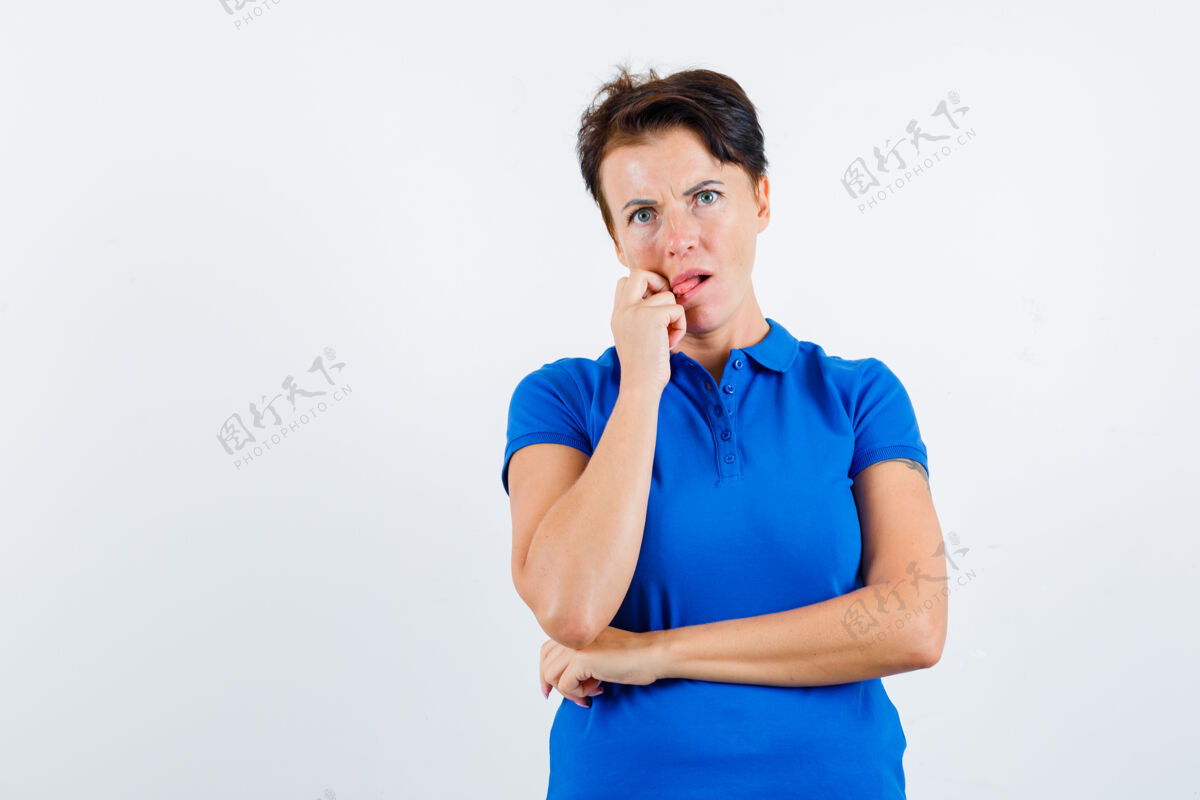 坚持穿着蓝色t恤的成熟女人伸出舌头思考 看起来很困惑前视图前面老年人休闲