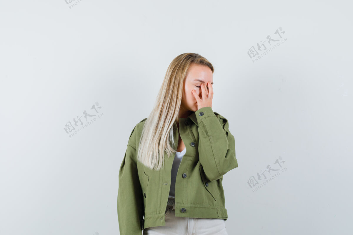 人穿着夹克 裤子的年轻女士手放在脸上 看起来很累前视图女士夹克抱着