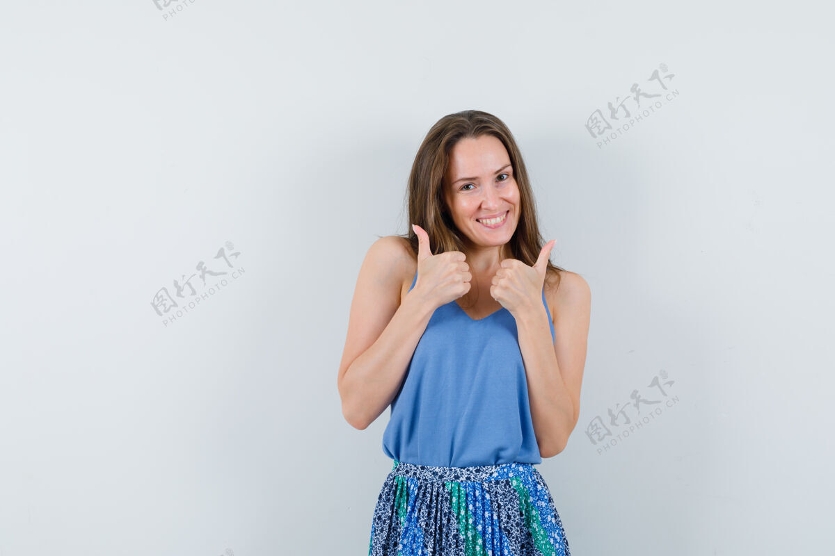 女孩穿着单衣的年轻女士 裙子竖起大拇指 看起来很开心 正面视图裙子自然秀