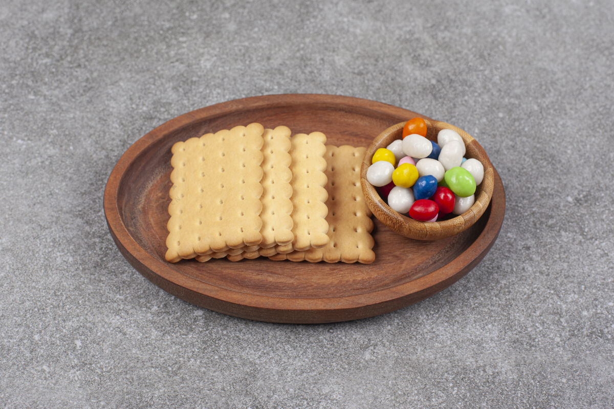 饼干饼干和五颜六色的糖果放在木盘上餐甜点小吃