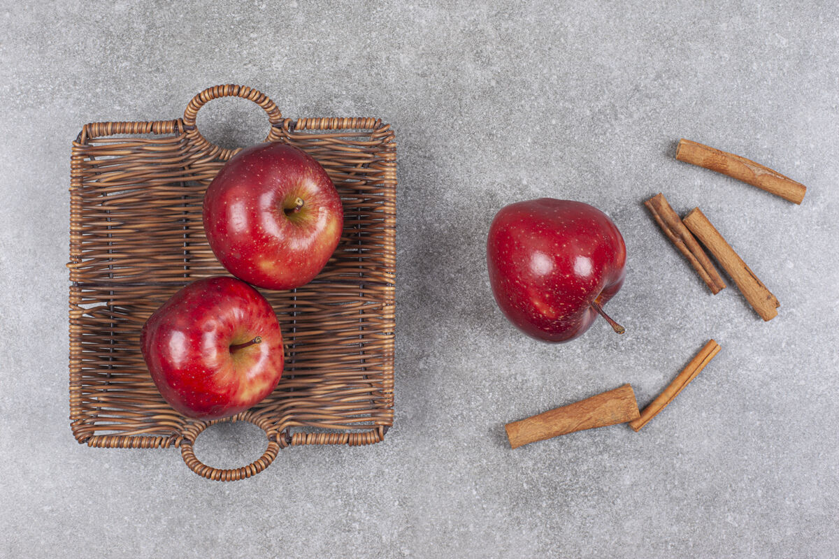 成熟的两个红苹果放在木筐里 里面有肉桂条肉桂天然农业
