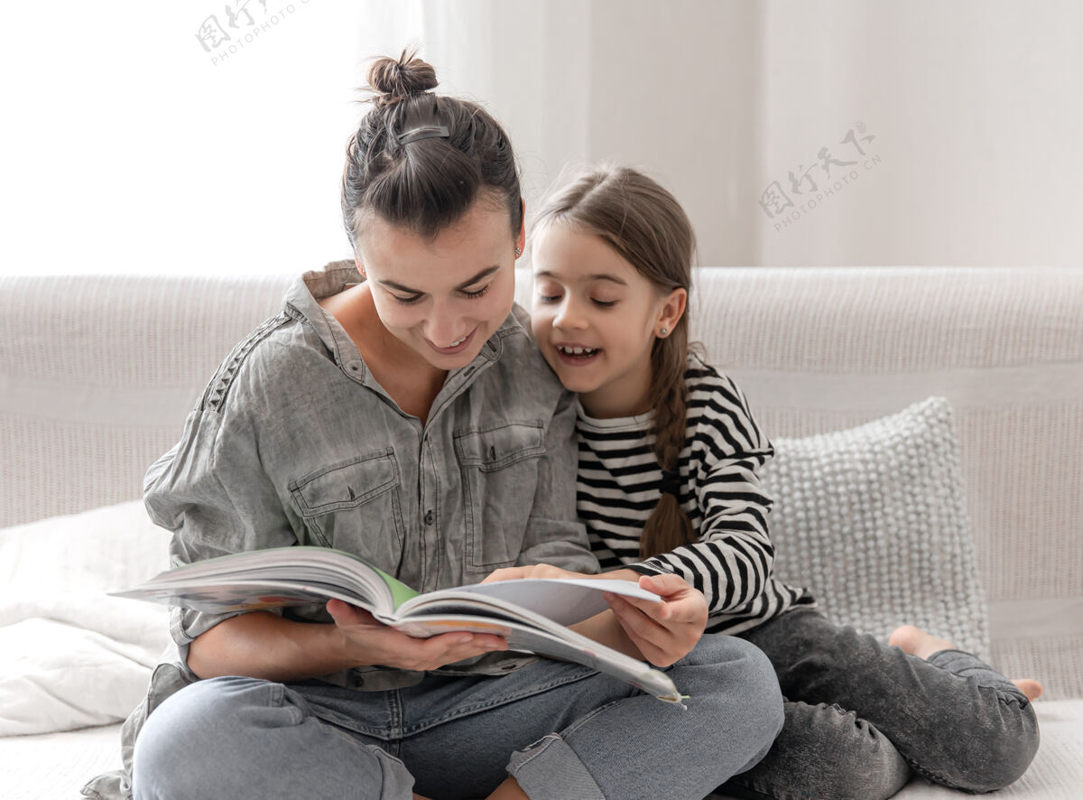 家庭作业开朗的妈妈和女儿在家休息 一起看书家庭阅读女儿