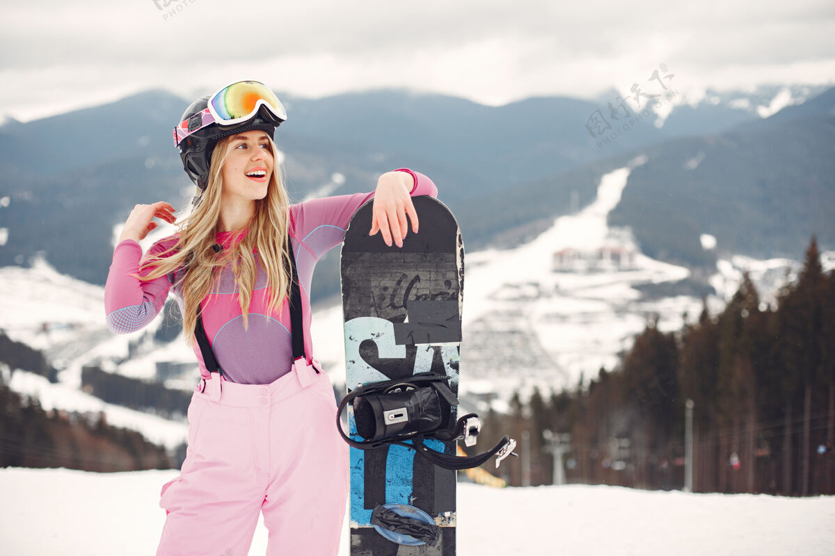 白色穿着滑雪板套装的女人在山上手拿滑雪板的运动员在地平线上关于运动的概念板女人活跃