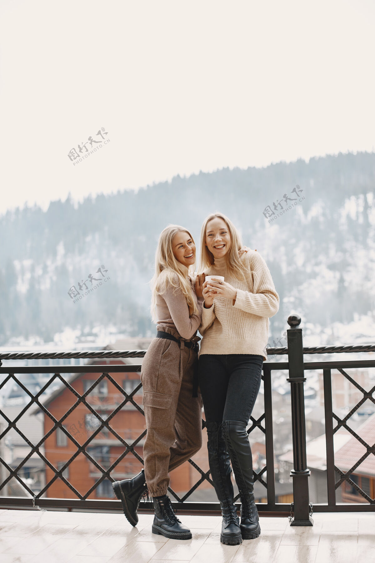 年轻穿着轻薄衣服的女孩阳台上的冬天咖啡快乐的女人在一起冬季冬天乡村