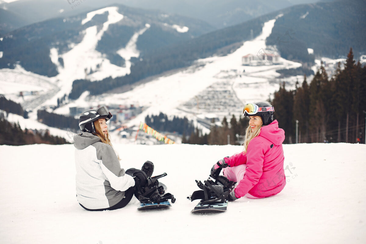 板穿着滑雪板套装的女人在山上的运动员手拿滑雪板在地平线上关于运动的概念自然女性坐