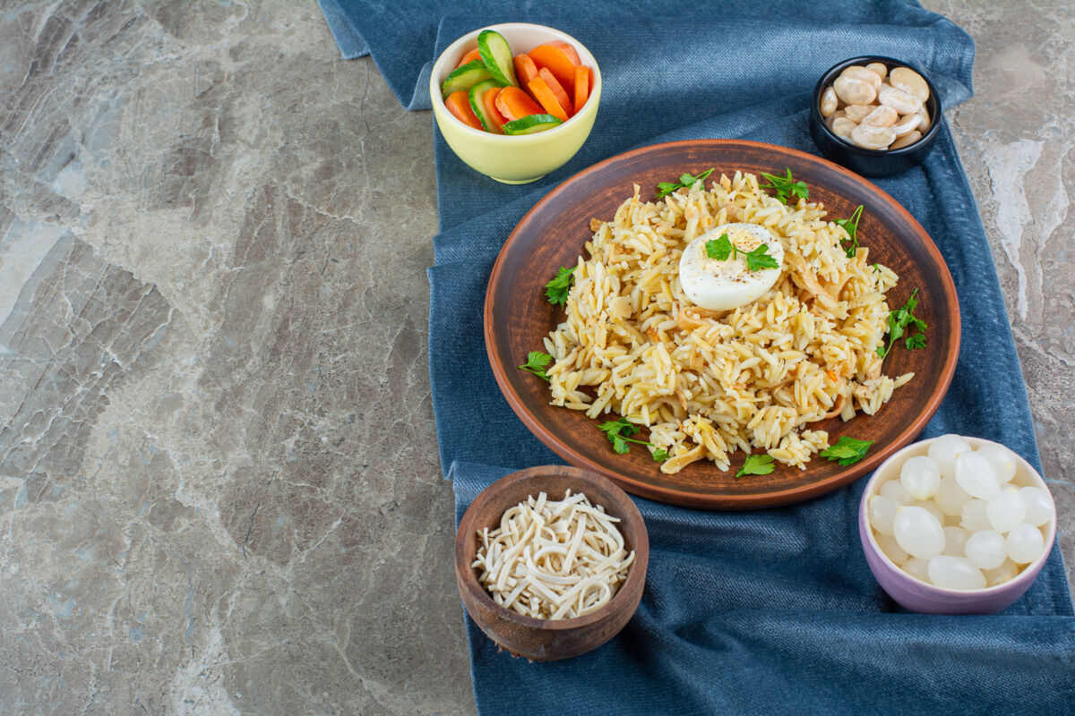 欧芹米饭和鸡蛋放在盘子旁边 各种材料放在一块布上 放在大理石上美味美味盘子