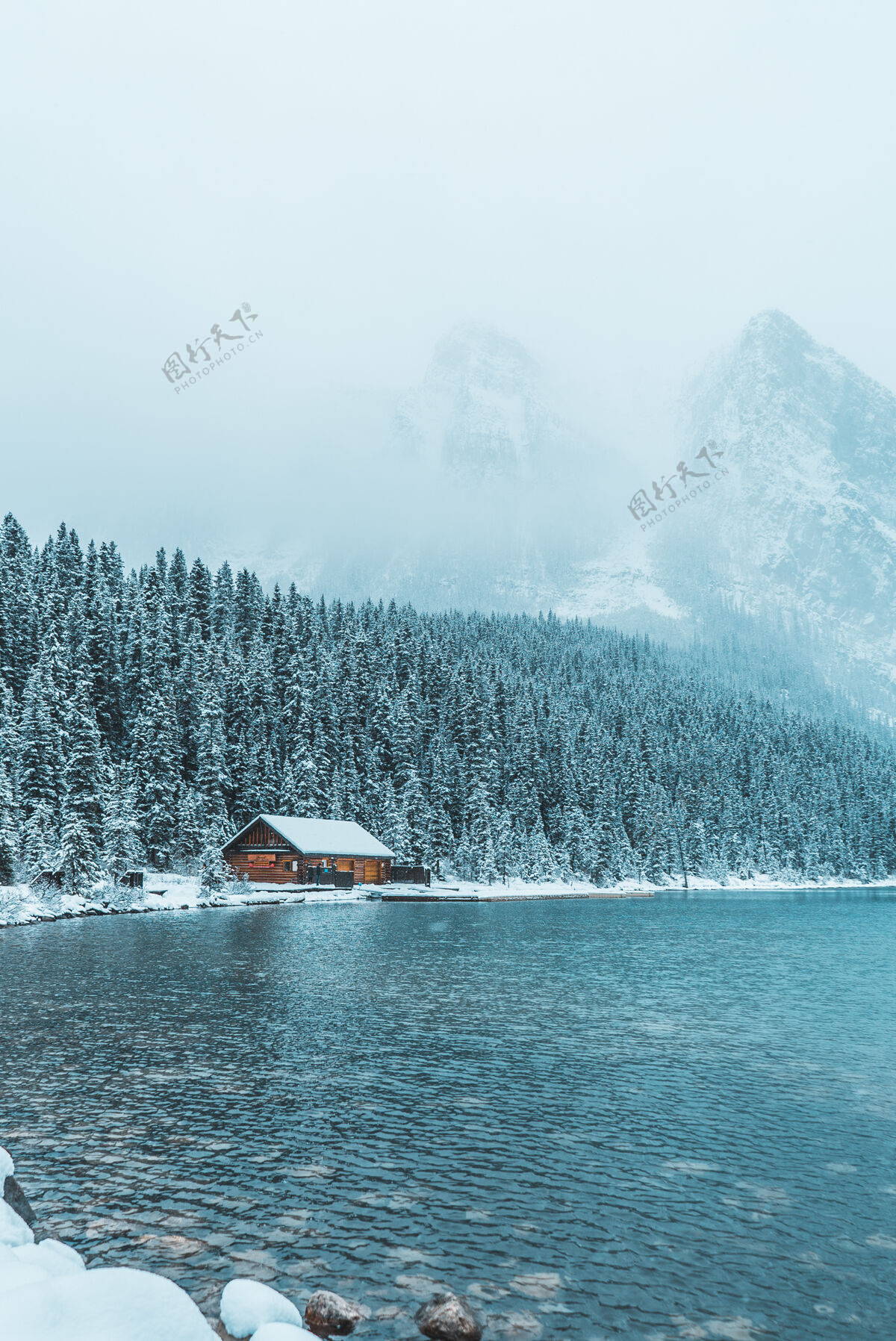加拿大冬天在树林和水体之间的棕色木屋自然冰川冬天