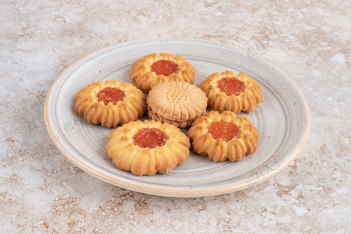 果酱一个装满果冻饼干的盘子 花形的放在石头表面上饼干面包房糕点