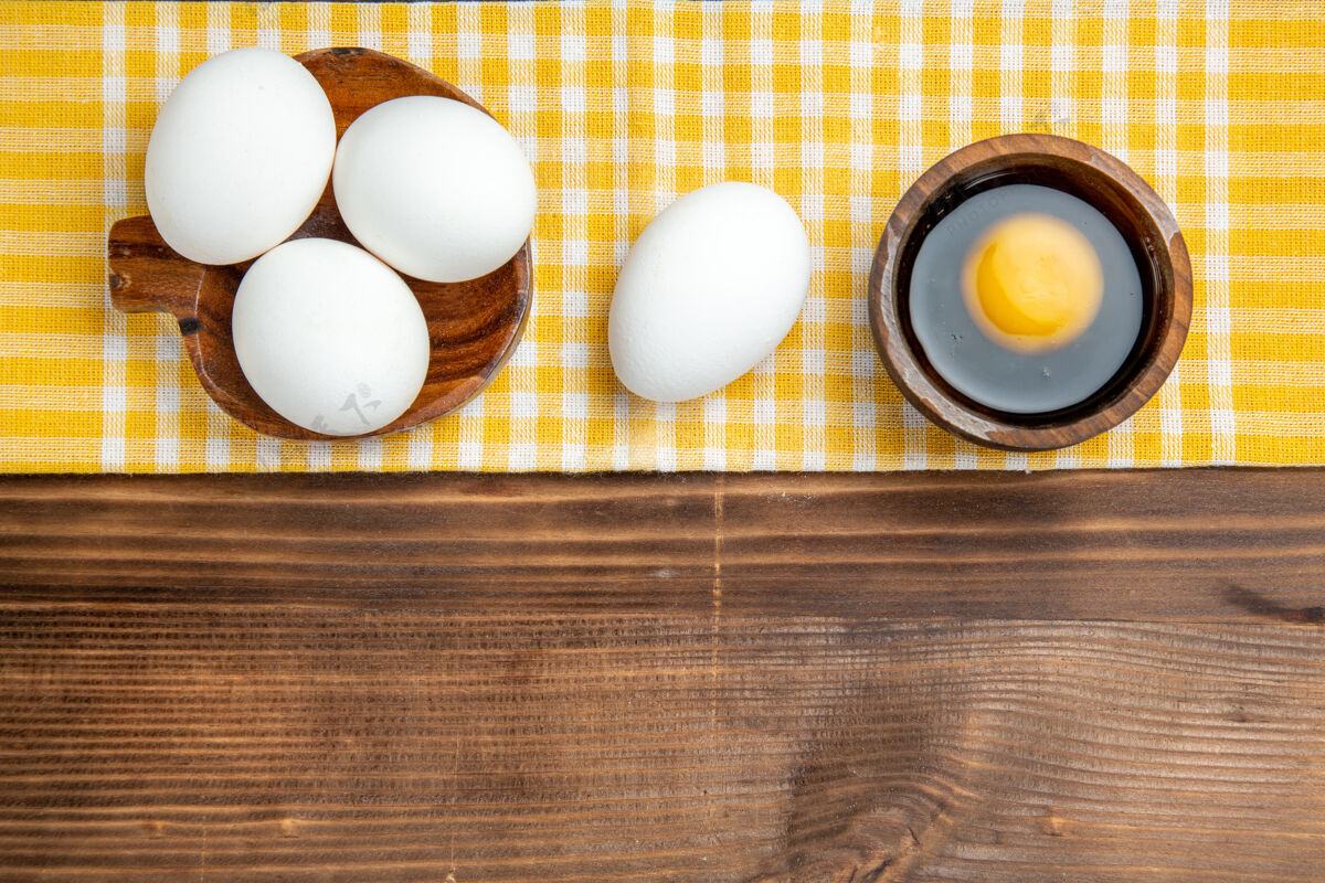 生的俯视整个生鸡蛋在棕色木制餐桌上的食物早餐木制鸡蛋早餐顶部鸡蛋