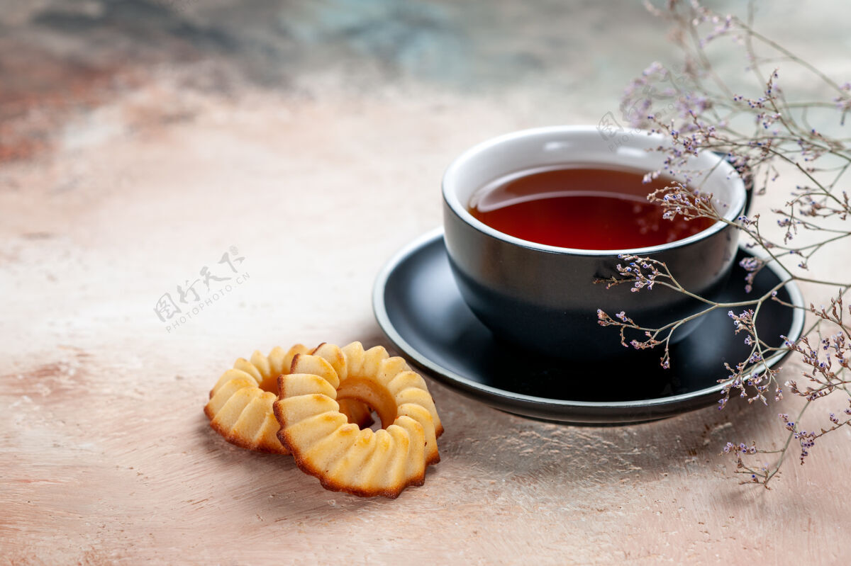 早餐侧面特写一杯茶一杯茶曲奇树枝茶马克杯热的