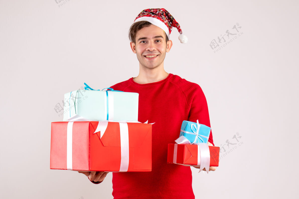 卖方前视图与圣诞老人帽子站在白色背景自由空间的年轻人礼物举行人