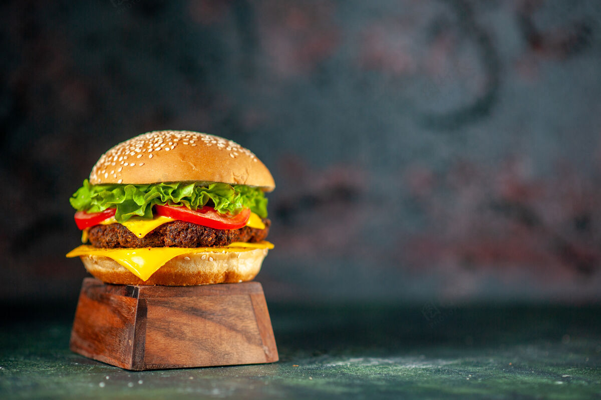 食物前视图美味的芝士汉堡在黑暗的背景肉生菜番茄