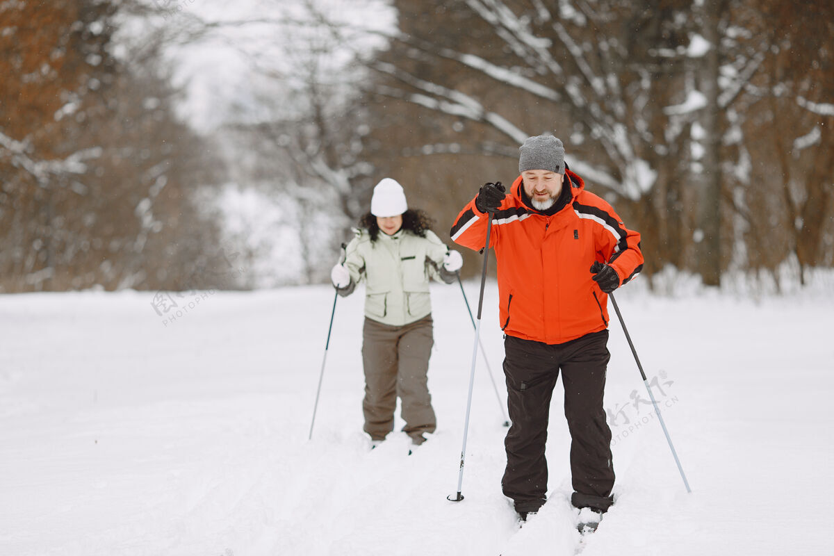 年龄冬季公园里快乐的成年夫妇人们穿着运动服在森林里悠闲地跋涉男人公园训练