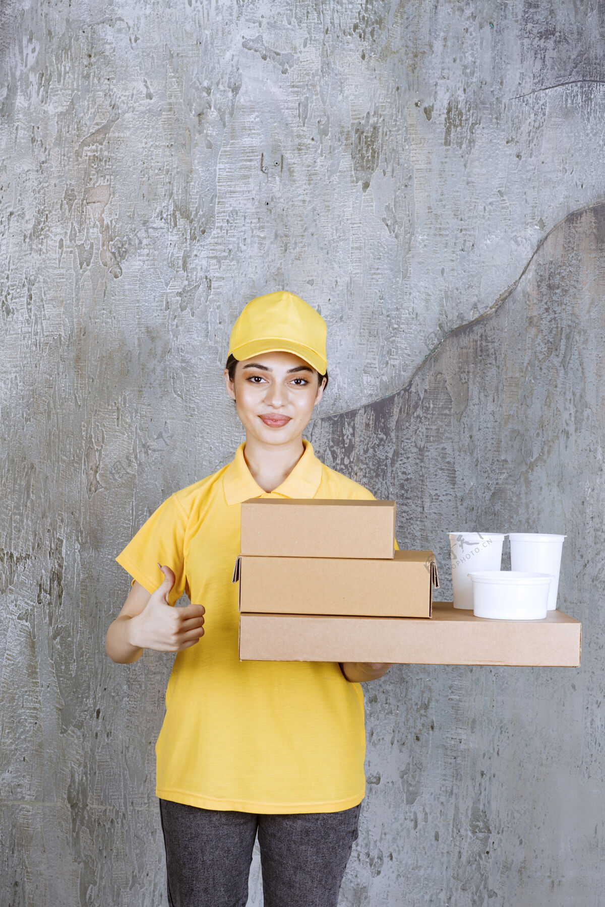 雇员穿着黄色制服的女服务人员手里拿着一堆外卖纸盒和塑料杯服务成人人