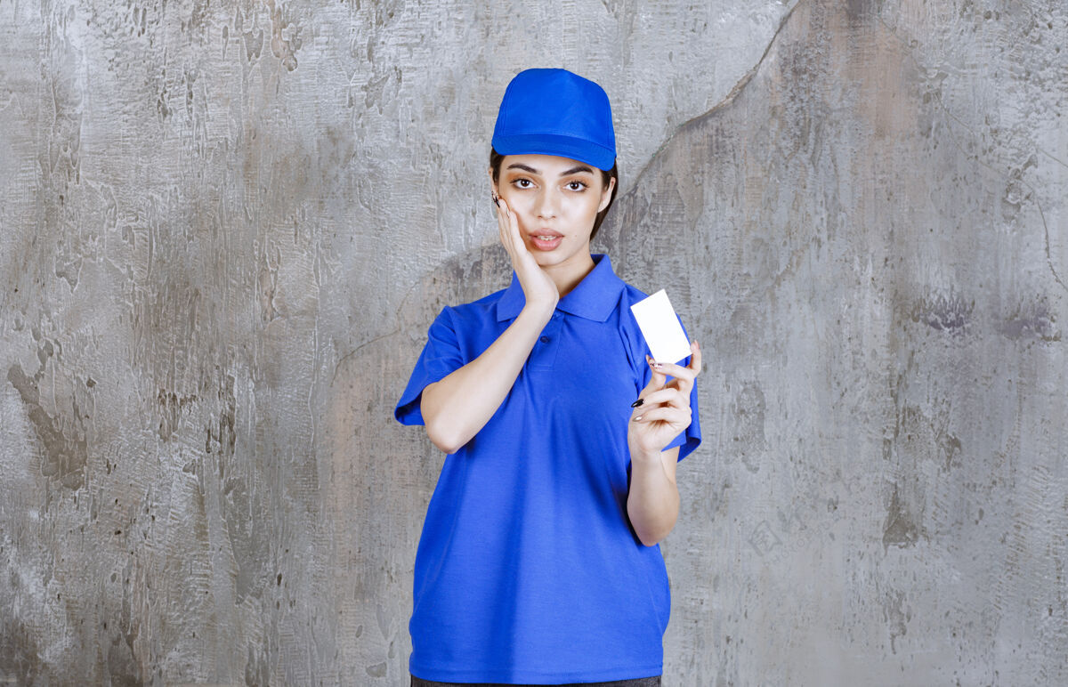 女性穿着蓝色制服的女服务人员出示名片 看上去很困惑或者很体贴电子邮件姿势惊讶