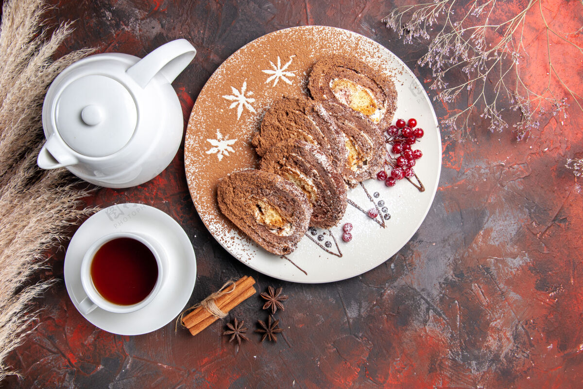 杯子俯瞰美味的饼干卷配上一杯茶放在深色的桌子上甜甜的蛋糕馅饼早餐热的早上