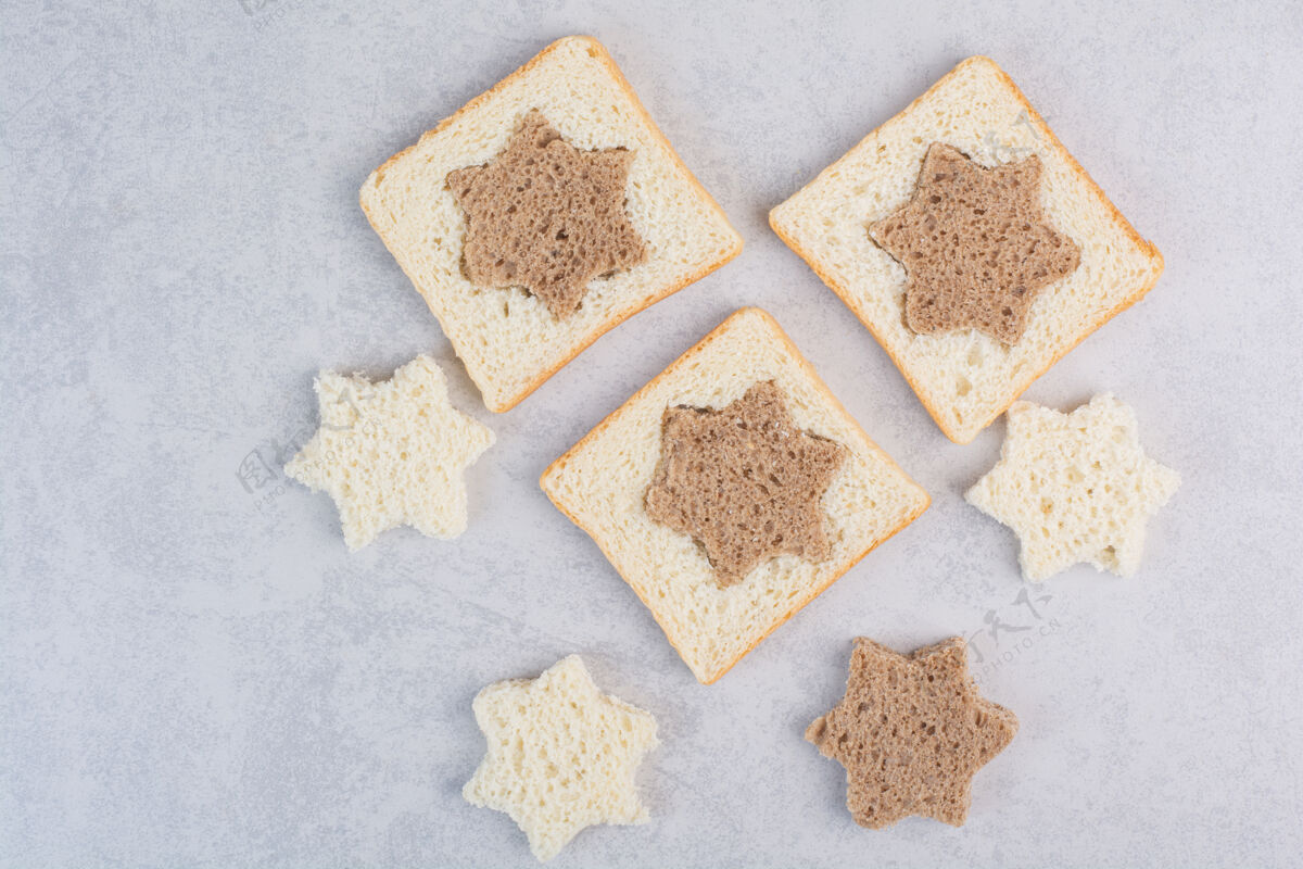 谷类石头表面的星形和方形黑白面包片小吃切割营养