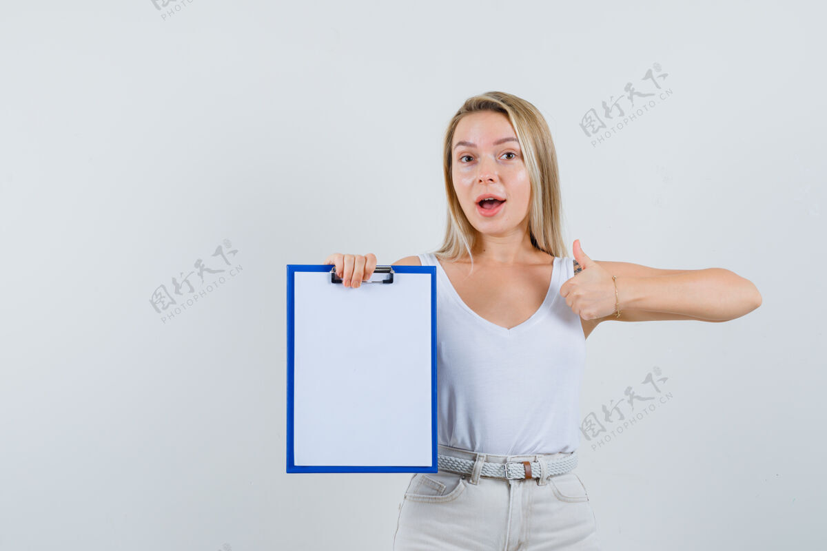 奢华一位年轻女士拿着空白的剪贴板 穿着白色上衣竖起大拇指 看上去很高兴头发衬衫显示