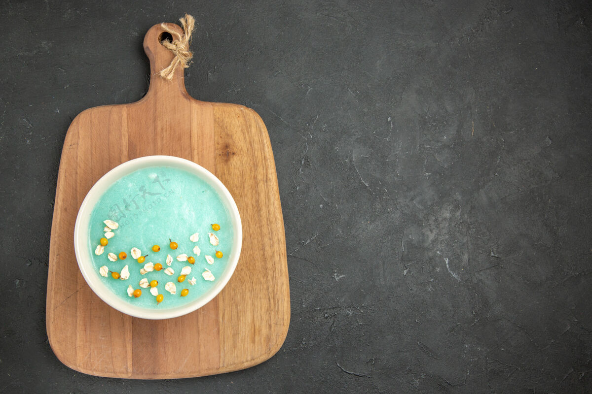 健康俯视图蓝色冰镇甜点在盘子里 放在深色的冰激凌上奶油容器烹饪