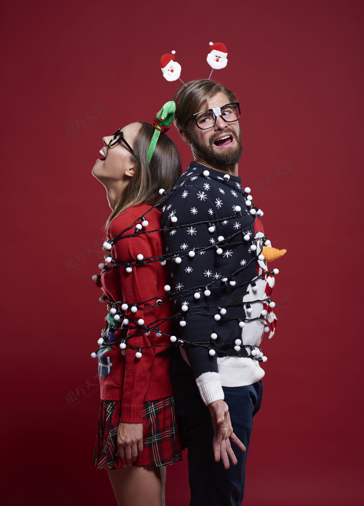 开衫一对穿着奇怪圣诞服装 系着圣诞灯的年轻夫妇圣诞节包装问题