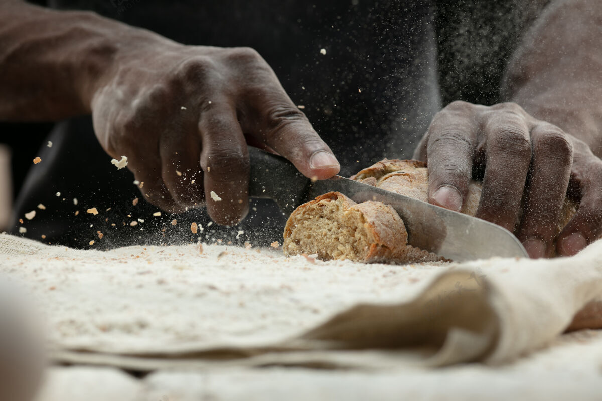 面包非洲裔美国人用菜刀切新鲜面包的特写镜头人年轻特写