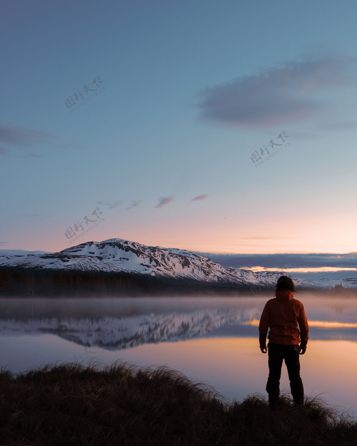 天一个男人站在美丽的海景前的垂直镜头湖泊海景自然