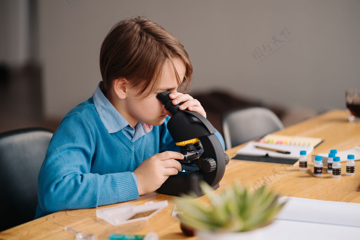 书房一年级男生在家用显微镜学习笔记坐着知识