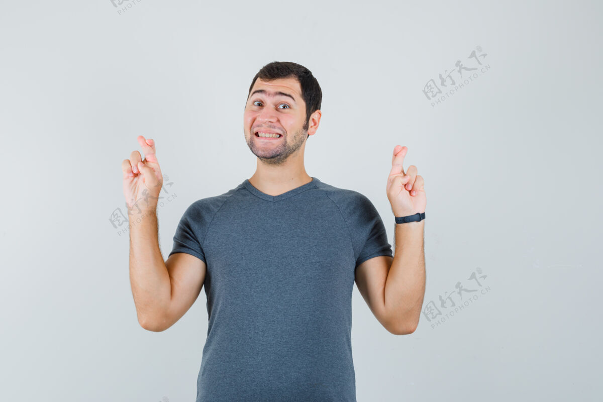 电子连接年轻的男性穿着灰色t恤 手指交叉 看起来很高兴男小商务网络摄像头