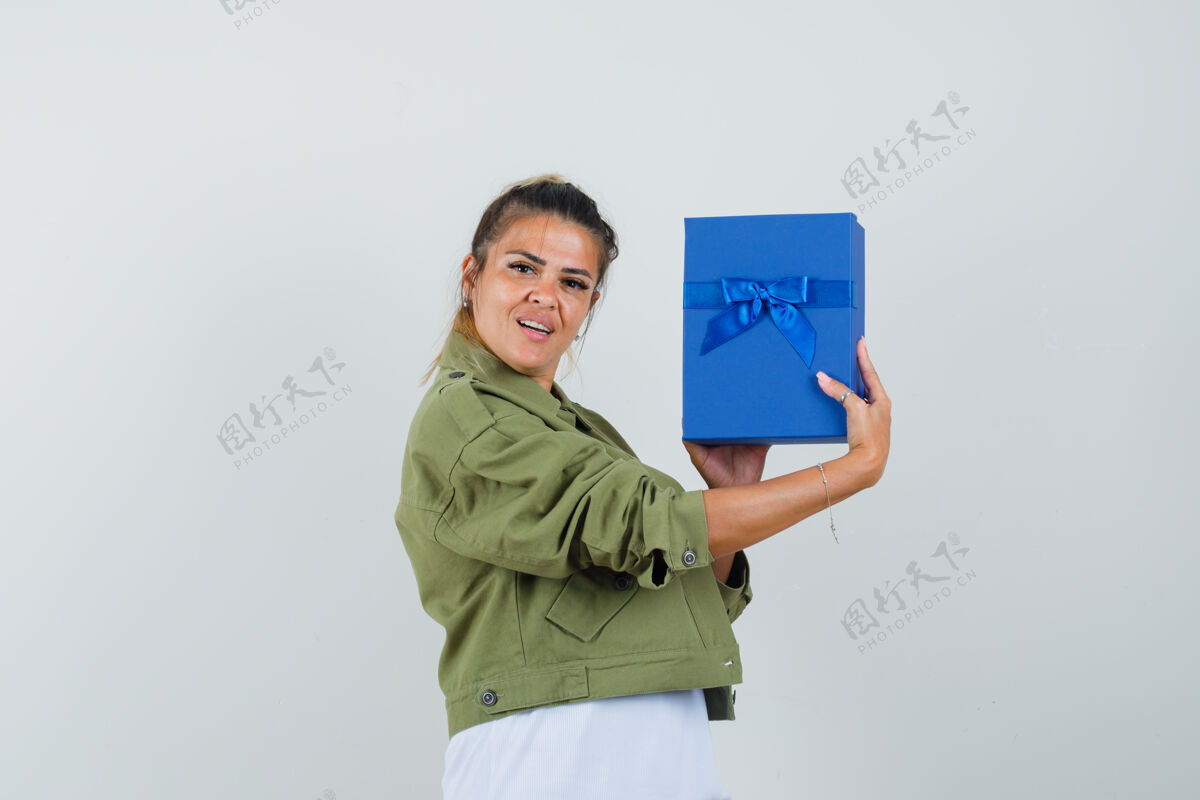 盒子年轻女士穿着t恤衫展示礼品盒 看起来很自信休闲人类黑发