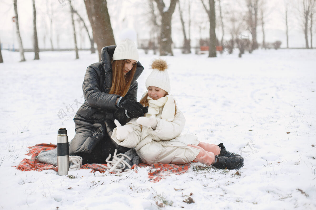 温暖一家人在度假时戴着编织的冬帽衣服季节自然