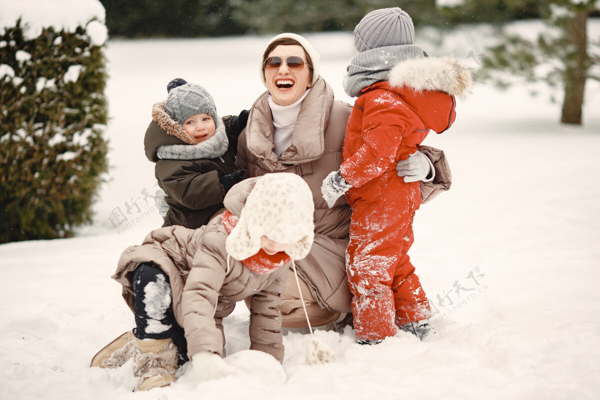 儿子一家人穿着冬装在雪林里度假户外针织品家庭