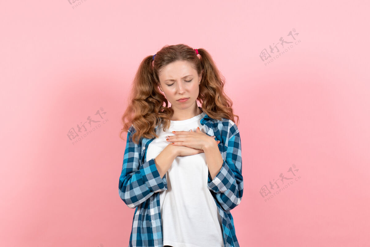 年轻正面图穿着格子衬衫的年轻女性在粉色背景上摆姿势年轻女性彩色情感模特儿格子成人情感