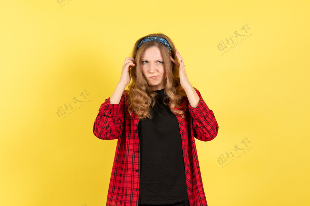 人正面图身着红色格子衬衫的年轻女性在黄色背景上摆姿势女孩女性情感模特彩色人类漂亮前面黑发