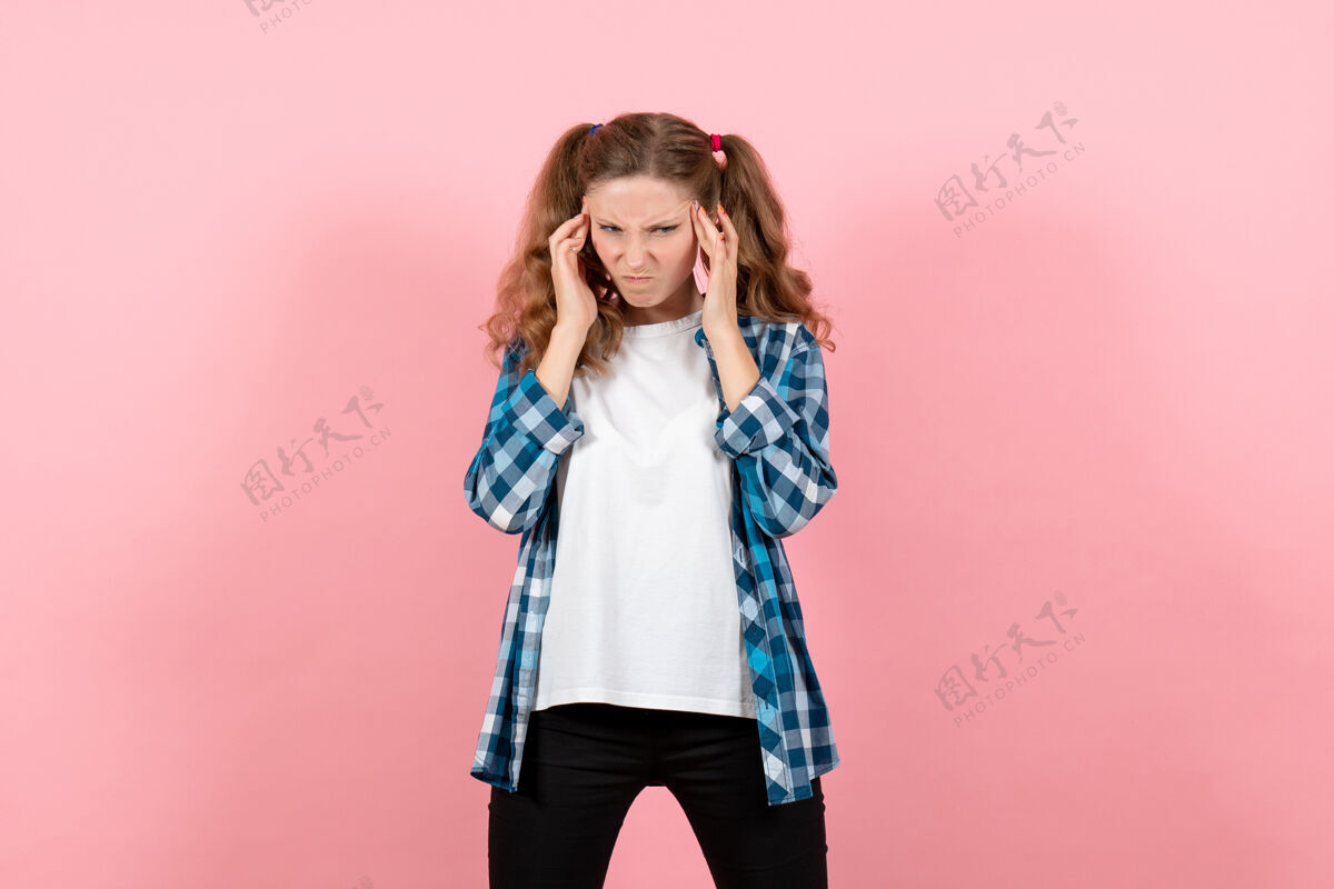 格子正面图穿蓝色格子衬衫的年轻女性摆姿势思考粉色背景上的女性儿童青春色彩情感模型衬衫思考年轻