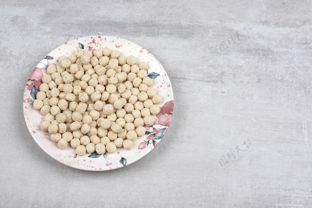 美味石头桌上摆满了玉米粒球的白色盘子玉米膳食脆