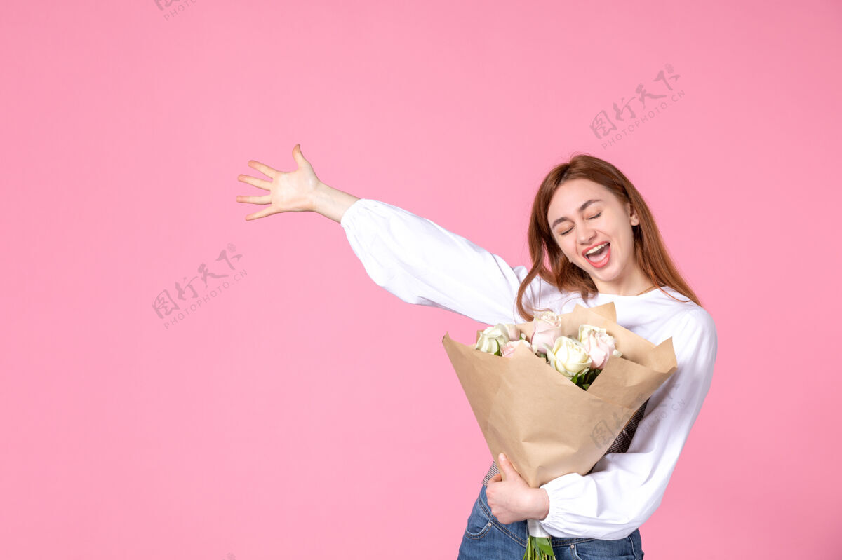 人正面图：带花朵的年轻女性 作为女性节礼物 粉色背景 水平女性三月女性性感约会玫瑰爱情花玫瑰年轻的女性