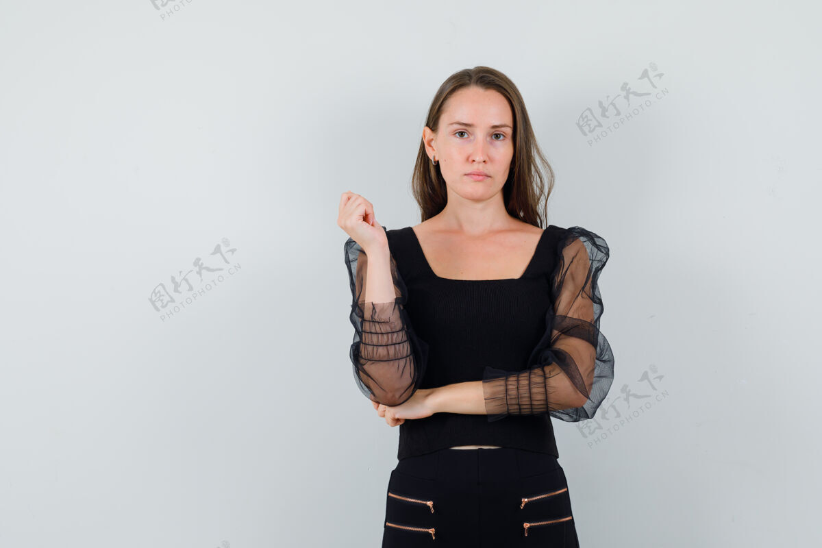姿势年轻女子摆姿势与她的手肘在黑色上衣 看起来很有吸引力前视图文本空间卷发化妆优雅