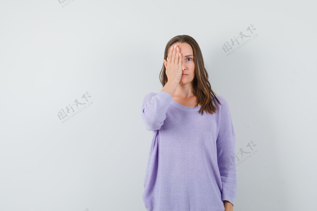 女性年轻的女性手拉着她的脸在淡紫色衬衫 看起来很平静手皮肤漂亮