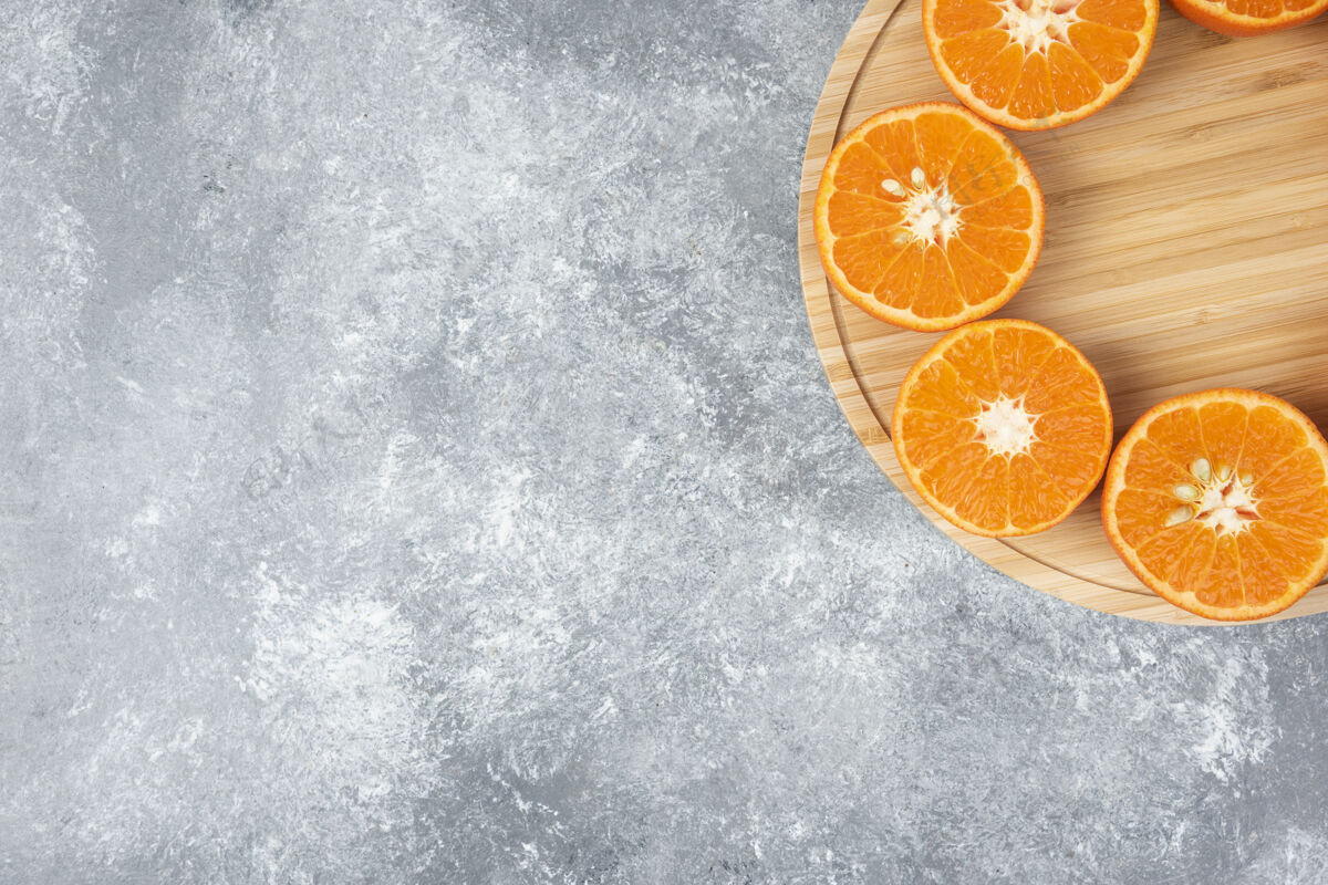 柑橘把新鲜多汁的橙子切片放在木盘里水果食物俯视图