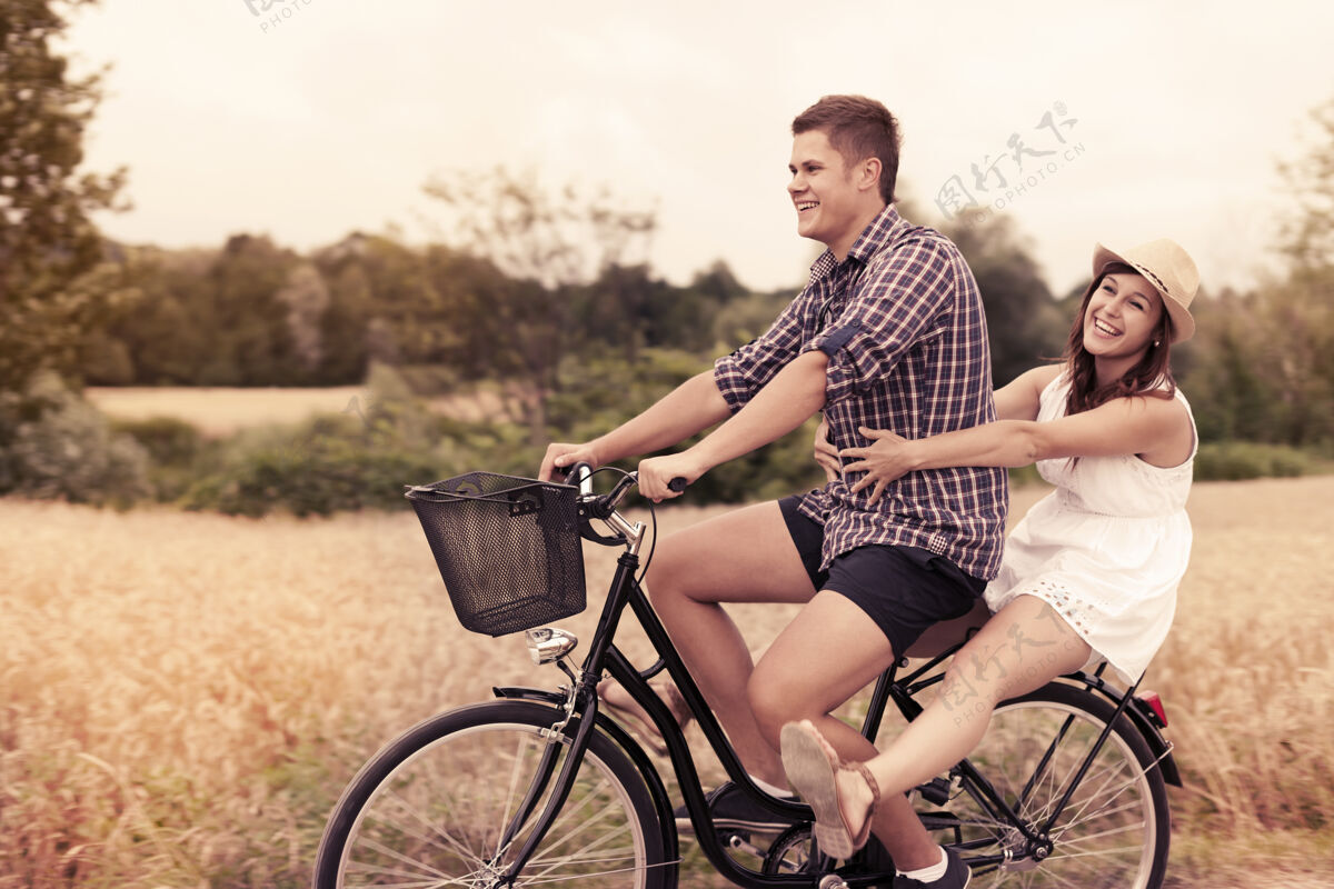 小麦夫妻俩骑自行车玩得开心纽带自然女人