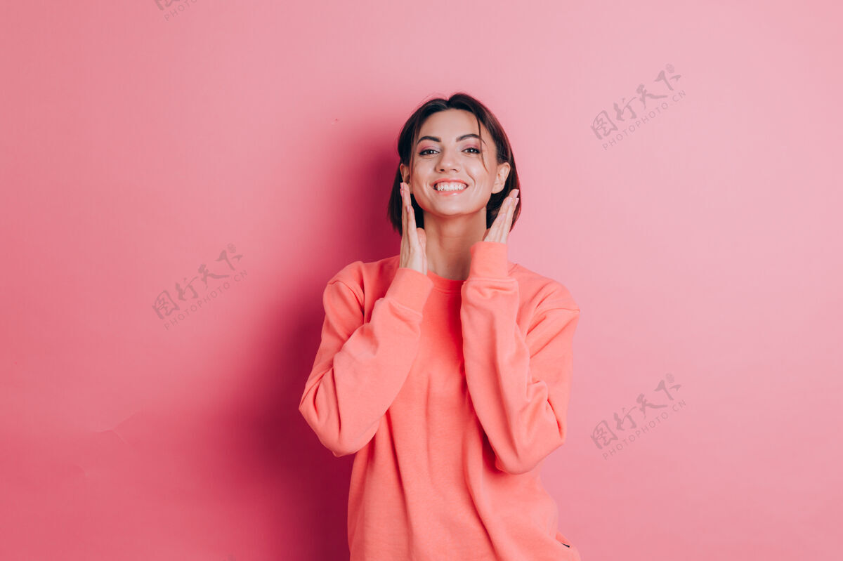 女孩美丽的微笑可爱的黑发女模特的肖像 穿着休闲的桃红色毛衣衣服 明亮的妆容和粉红色的嘴唇时尚快乐女士